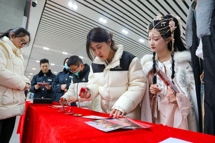 图为宝鸡南站举办候车室里赏“何尊”主题活动，旅客正在参与打卡集印章兑换新年小礼品。（西安铁路局供图）