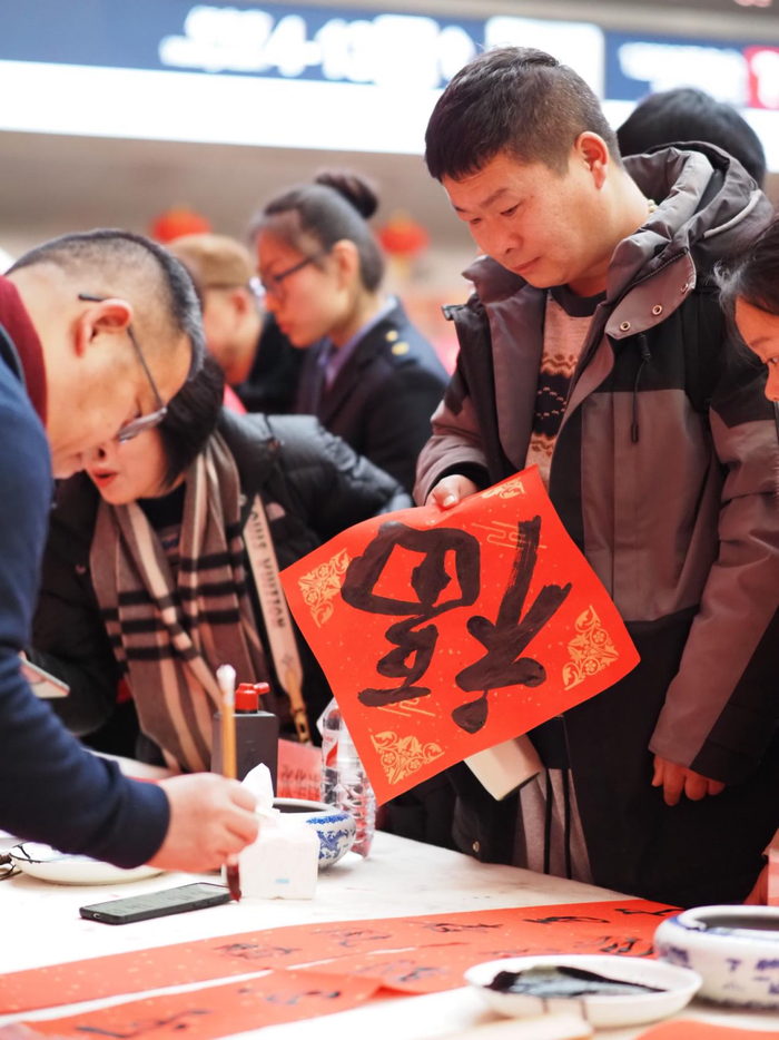 摄于北京西站“万福迎春·福满京城 艺润万家”春节文化惠民·书法公益活动现场。（国铁北京局供图）