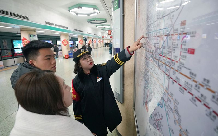 北京地铁前门站区副站区长倪然正在帮乘客规划出行路线。新京报记者 王贵彬 摄