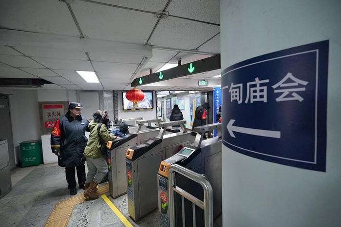 和平门站值班站长张东然引导前往厂甸庙会的乘客有序通行。新京报记者 王贵彬 摄