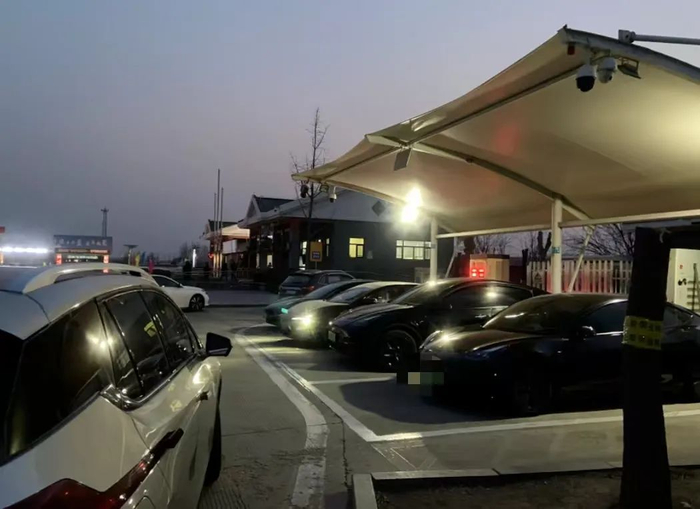 在大广高速公路冀州服务区，四辆新能源车正在充电，一辆新能源车在排队等候。本报记者 王可/摄