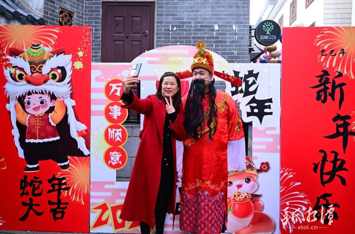 与财神合影，新年图个好彩头。（全媒体记者 陈旭东 摄）