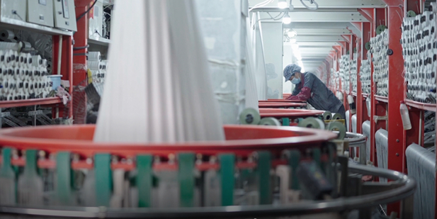 在“盈创回收”的食品级再生工厂里，工人在回收塑料的再加工生产线上忙碌着