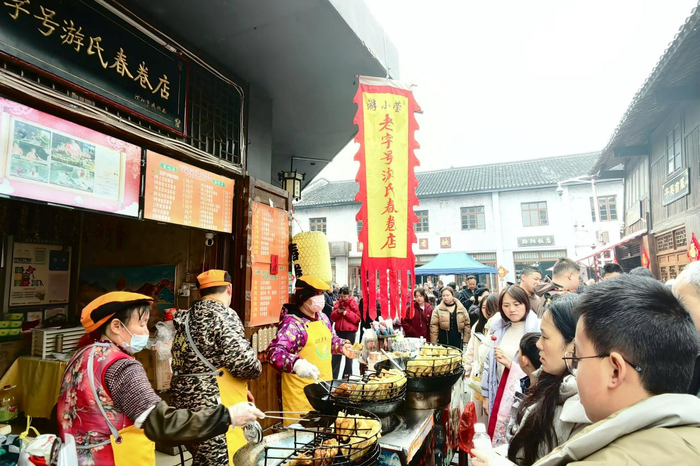 游客在黔阳古城品尝当地特色小吃春卷（蒋慧明 摄）