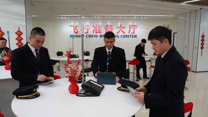   李富新（左二）和其他飞行员一起检查、校对放行资料