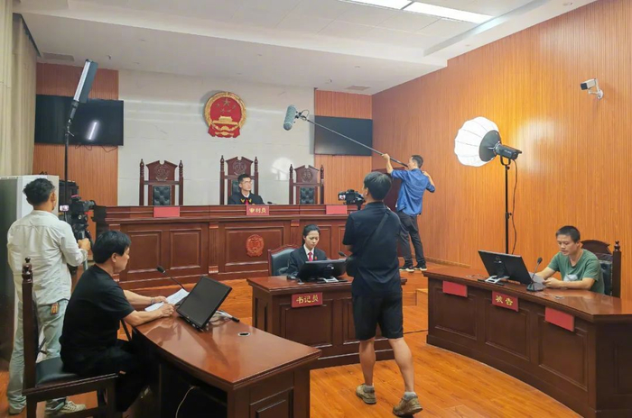 （图为审判案件拍摄现场）