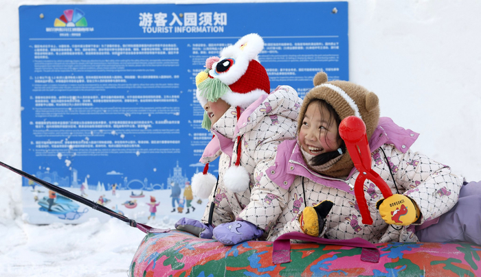 两个小孩在体验滑雪圈的速度