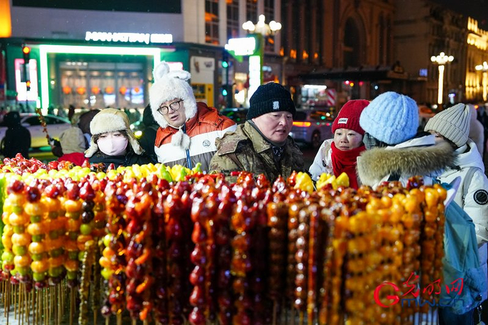 正月初三，游客在哈尔滨街边选购冰糖葫芦。
