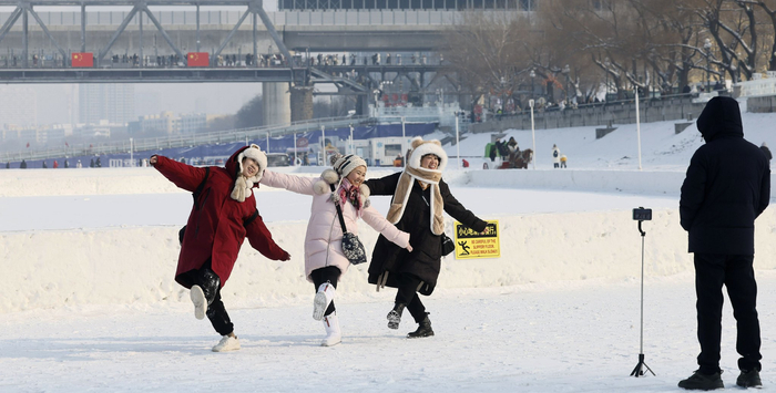 松花江上，旅拍从业者正在为游客拍摄