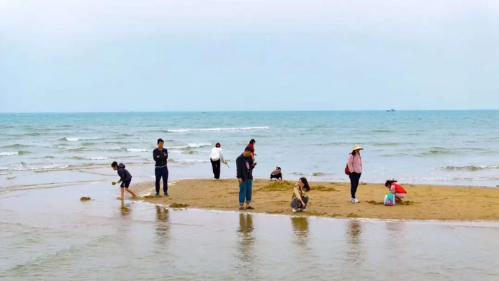 游客正在沙滩上玩耍。杨川 摄