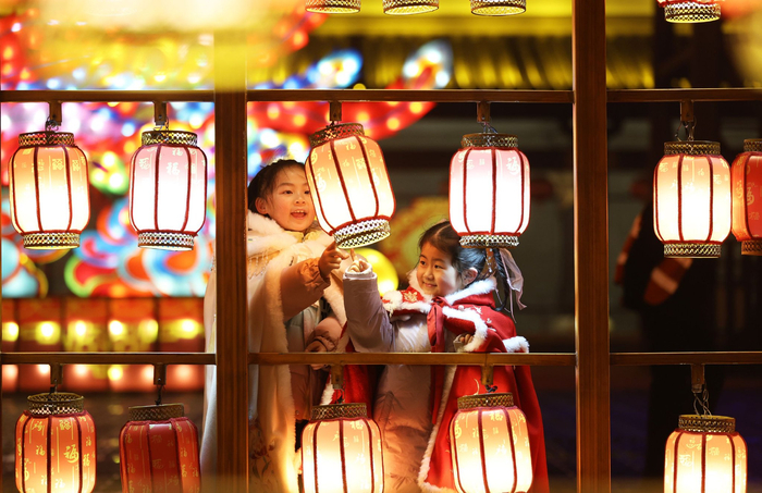 2025年1月31日晚，在山东省临沂市郯城县郯国古城景区，两名穿着传统服饰的小女孩在观赏花灯。 新华社发（张春雷 摄）