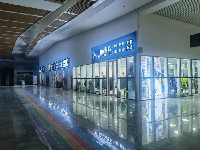 崇礼区太子城高铁站出口外，有多家雪具店，“教练预约”作为招牌服务项目被挂在门牌上。摄影/李明子