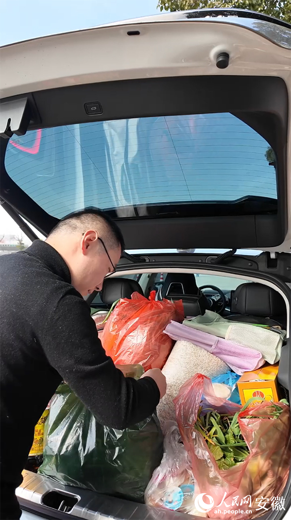 周鹏在收拾后备箱。人民网记者 王锐摄