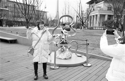 图为2月8日，影迷在成都天府长岛数字文创园哪吒形象雕塑前合影。    新华社记者 江宏景摄