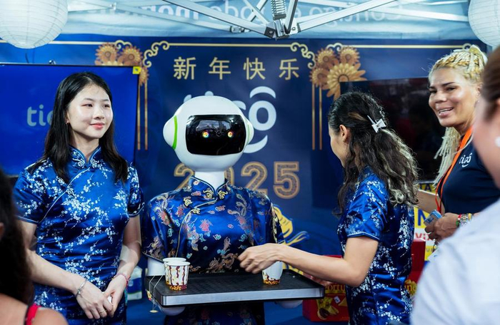 1月31日，在巴拿马首都巴拿马城的华侨华人欢乐春节庙会上，机器人为游客送上中国茶水。新华社记者 许咏政 摄