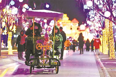 游客在北京世园边骑车边赏灯 摄影/北京青年报记者 袁艺 