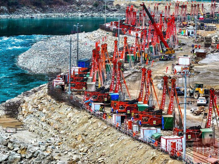 河岸边，82台红色冲击钻机正在作业