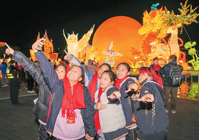 第二十三届“两马同春闹元宵”交流活动上，两岸同胞在花灯前合影。原浩 摄