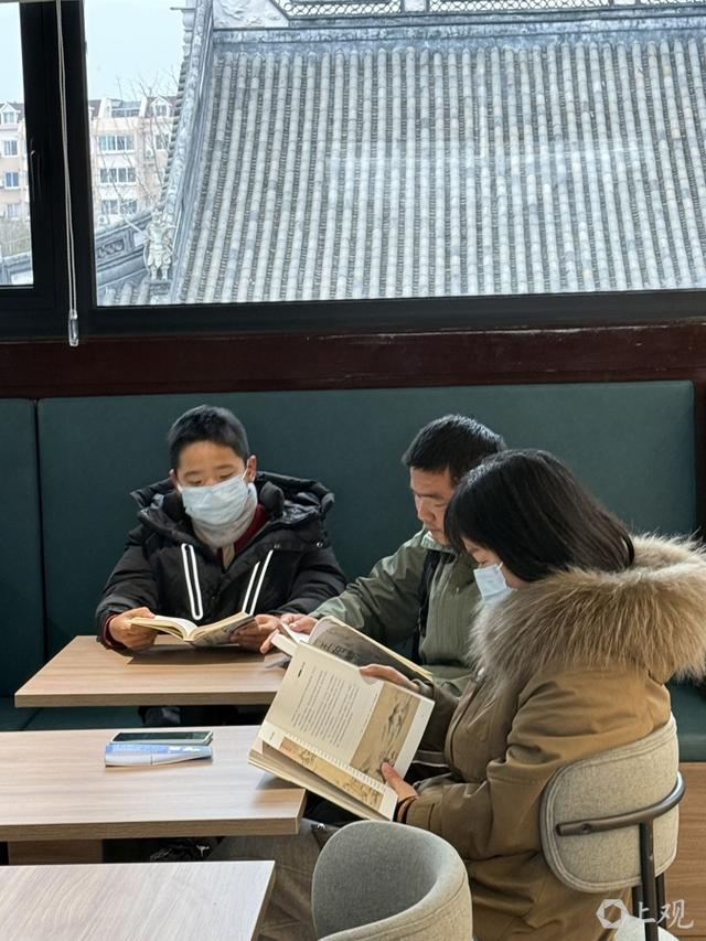 记者遇到一家三口认真阅读。施晨露摄