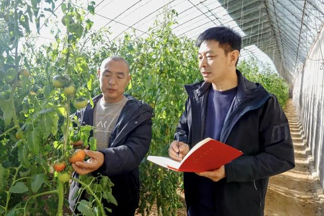 本报记者王官波（右）在辽宁省北票市娄家店乡扎兰营村采访（王化龙 摄）
