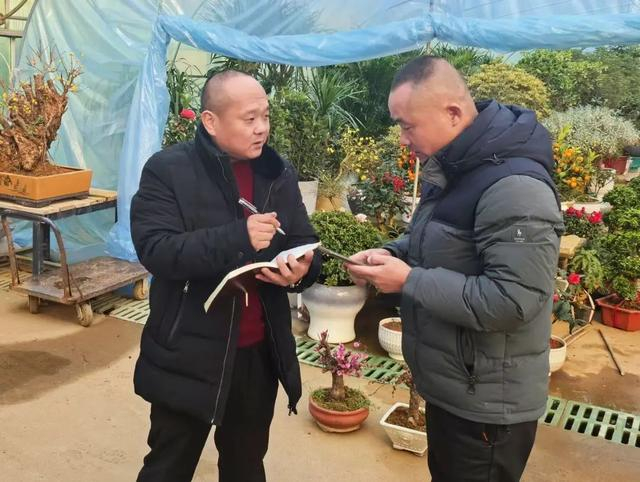 本报记者张伟伟（左）在江苏沭阳国际花木城采访 （相哲 摄）
