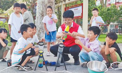 刘华东和小朋友们在做科学实验。资料照片