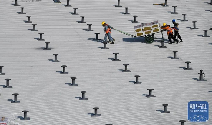 2月9日，在三亚凤凰国际机场三期改扩建项目施工现场，工人在T3航站楼钢结构屋顶施工。赵颖全 摄