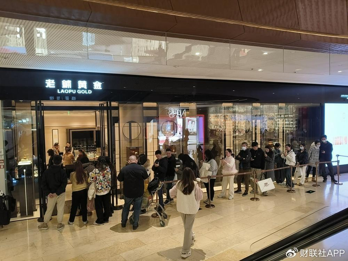 晚上八点左右，老铺黄金店前大排长龙 财联社记者摄