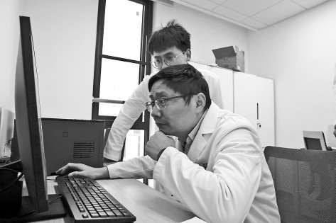 宣武医院专家曹锋与雄安宣武医院年轻医生讨论患者病情。本报记者 王雅贤 摄