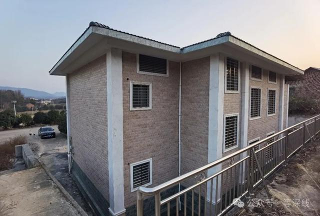 佘智江老家右后视图，用材考究之外，依旧是密集的不锈钢方形钢管防护网，焊满每一个窗口或通风口。程维/摄影