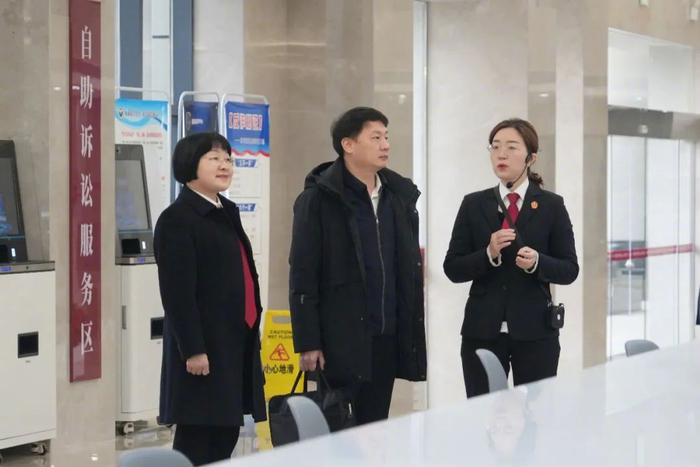 图为全国人大代表黄乐（左二）参观湘潭中院诉讼服务中心。