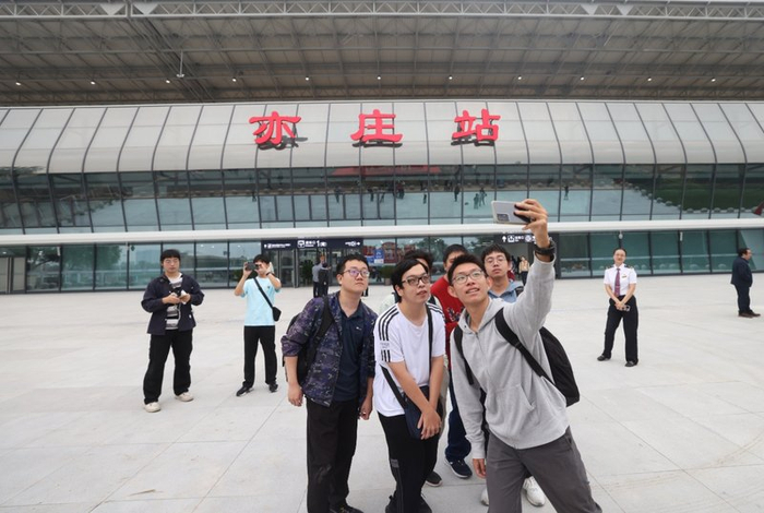 2024年9月29日，乘客在亦庄火车站前合影留念。资料图/新京报记者 王贵彬 摄