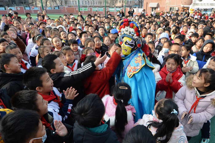 　　  2月14日，学生们在山东青岛四方小学“传统文化润童心”主题活动中与川剧变脸演员互动。新华社发（王海滨摄）