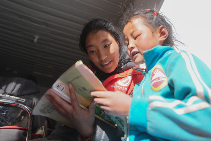 　　  1月25日，在定日县曲洛乡热木青村安置点，大学生志愿者在安置点在给孩子们辅导功课。新华社记者 晋美多吉 摄