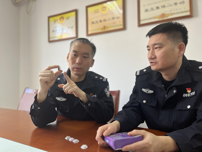 秦向铭（左）和同事对涉案减肥食品进行分析研判。