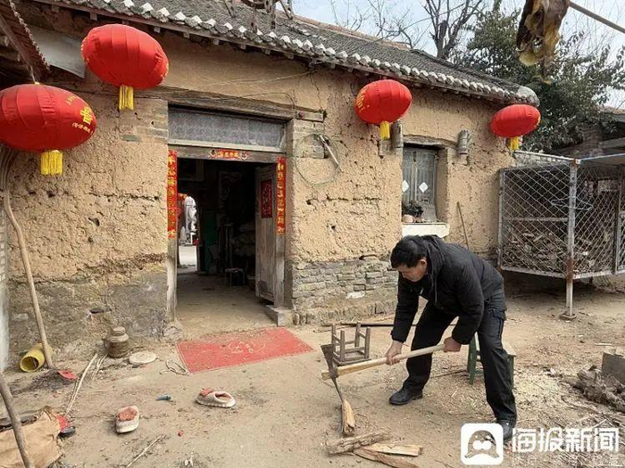 朱之文在家中院子里劈柴。