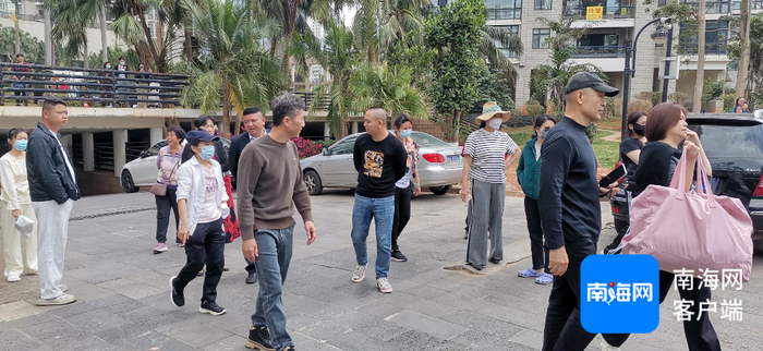 小区业委会成员与业主在小区门口阻止午托机构带孩子进入。记者 王康景 摄