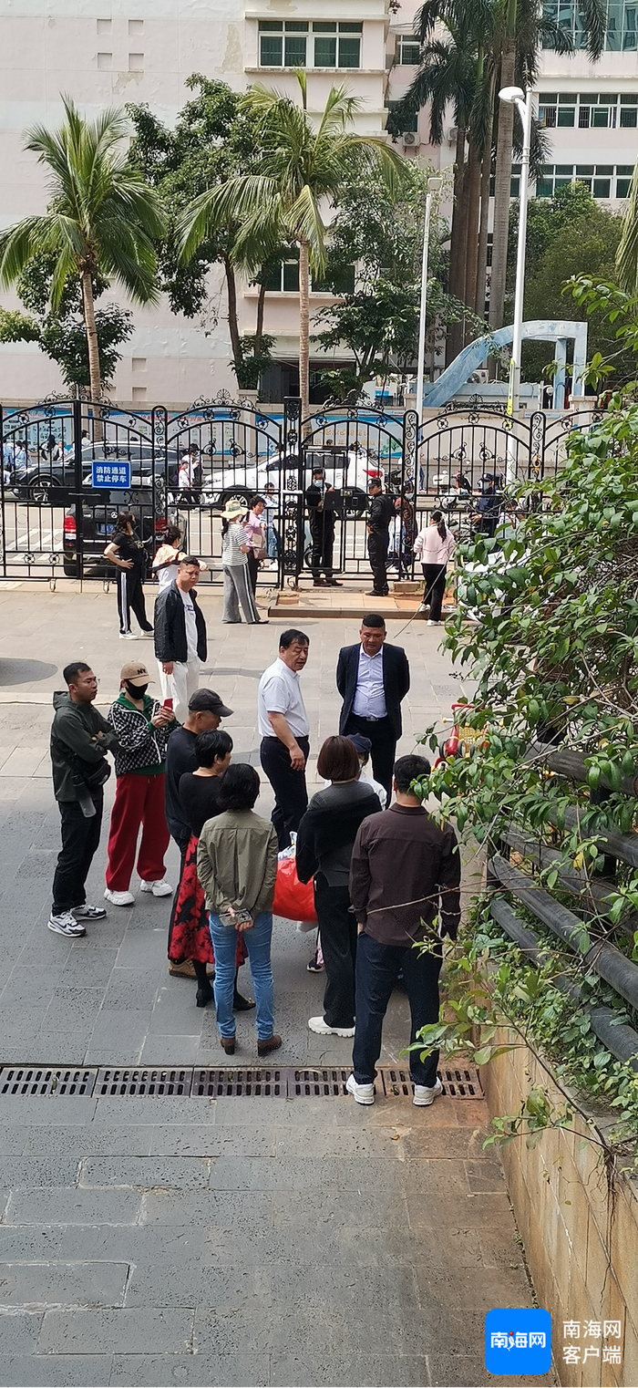 小区业委会成员与业主在小区门口阻止午托机构带孩子进入。记者 王康景 摄