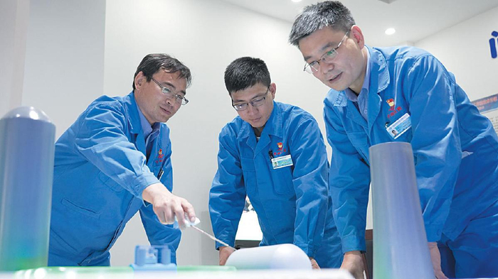 郭佳宁（左一）和同事们在创新工作室开展学习交流。