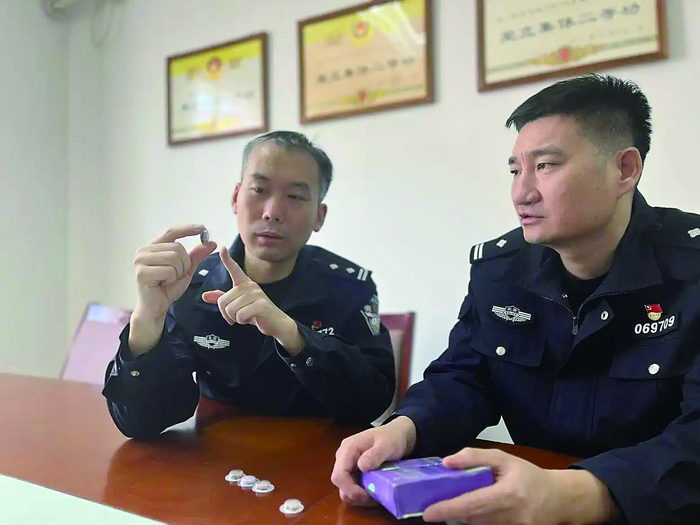     秦向铭（左）和同事对涉案减肥食品进行分析研判