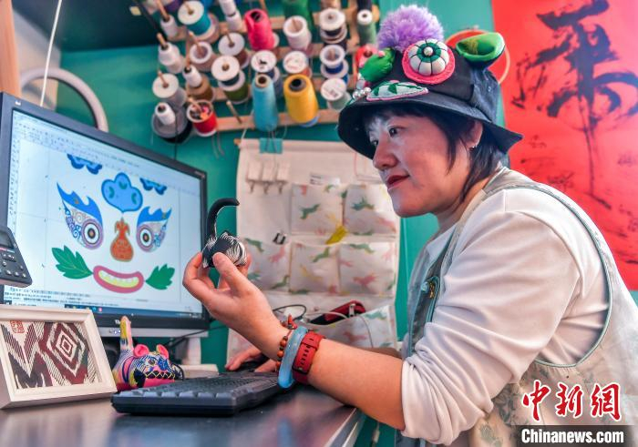 2月20日，新疆乌鲁木齐市倾城布老虎文创工作室，马秀玲在电脑上设计布老虎图案。中新社记者 刘新 摄