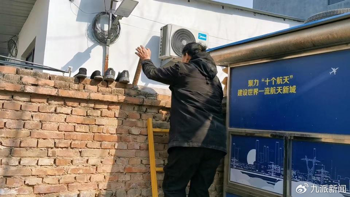 因门外围观的人太多，朱之文与邻居在共用的墙上架起梯子通行。图/九派新闻　温艳丽