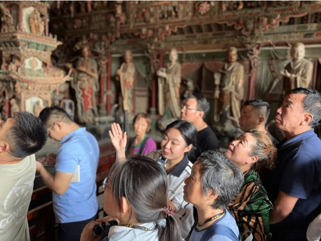 讲解员为游客讲解悬塑艺术。图源：新华社