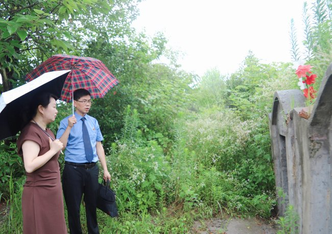 2024年6月，湖北省红安县检察院检察官邀请全国人大代表程星（左一）共同查看林清芝烈士墓破损情况。