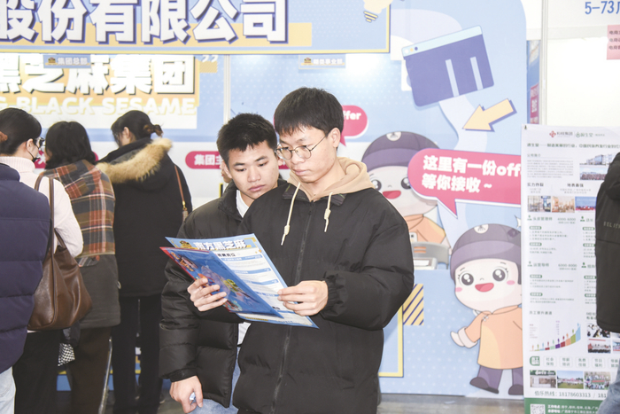     求职者在现场了解企业招聘相关信息。    本报记者黄红锦摄