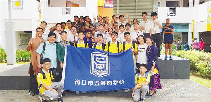 2019年，陈学汉（二排左一）等人和海口市五源河学校学生在新加坡留影。陈学汉供图