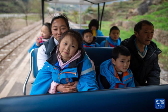 2月23日，云南省宣威市普立乡尼珠河村的小学生们在家长的带领下乘坐景区观光车。新华社记者 江文耀 摄