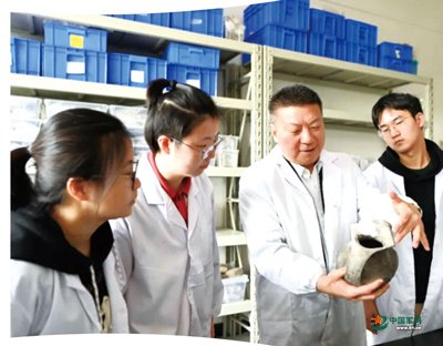 　　霍巍（右二）在实验室为学生讲解。