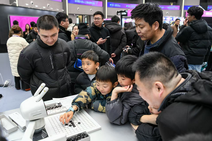 现场小观众正在与机器人“切磋”棋艺。劳动报记者颜筱依摄