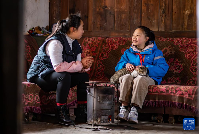 2月23日，云南省宣威市普立乡尼珠河村的小学生陈泓函出发前在家跟妈妈聊天。新华社记者 江文耀 摄